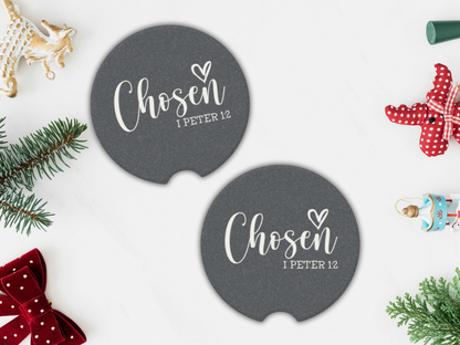 Two navy coasters with 'Chosen 1 Peter 1:2' text, surrounded by Christmas decorations on a white background.