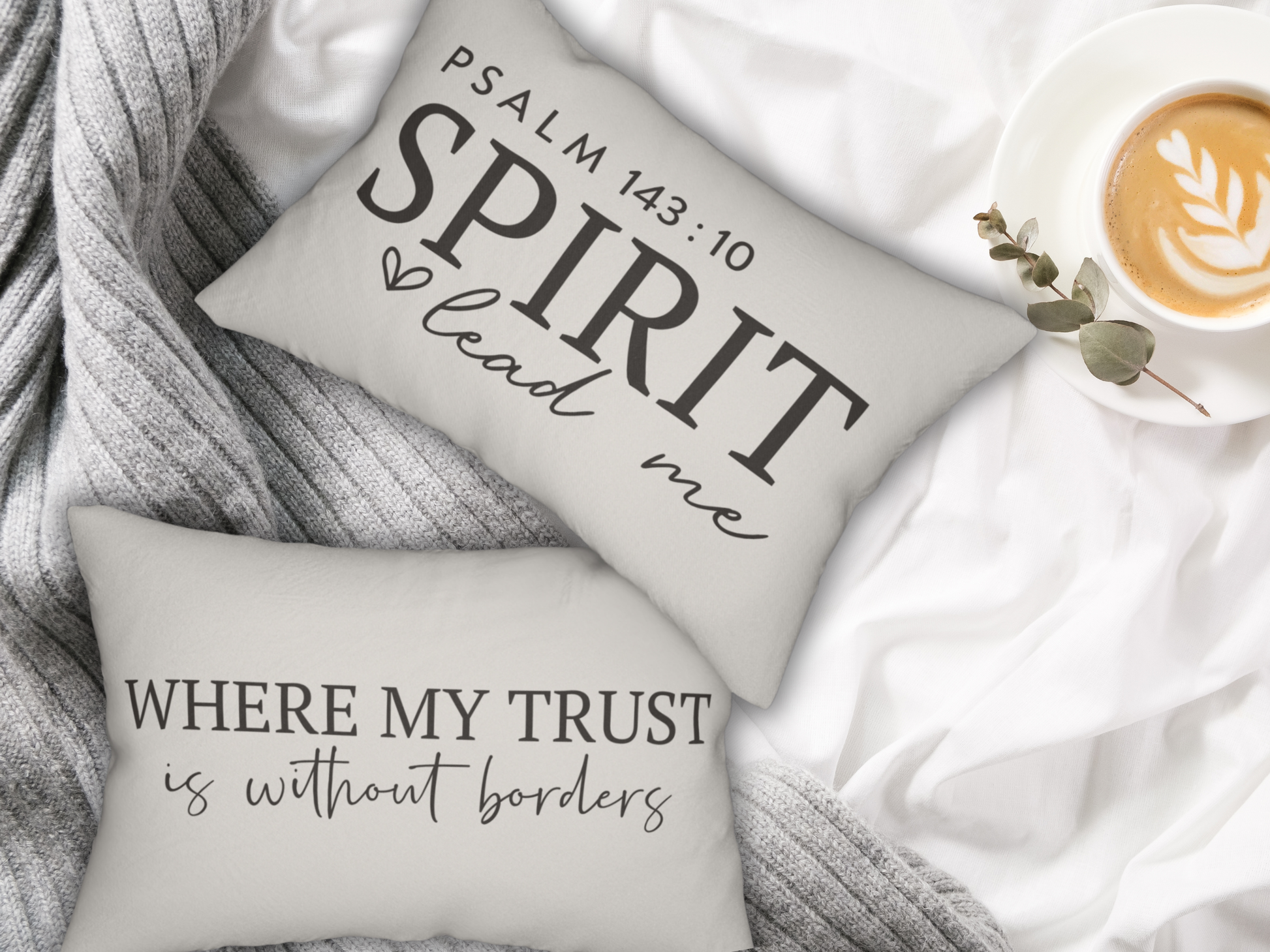 Decorative pillows with inspirational quotes on a soft surface with a cup of coffee.