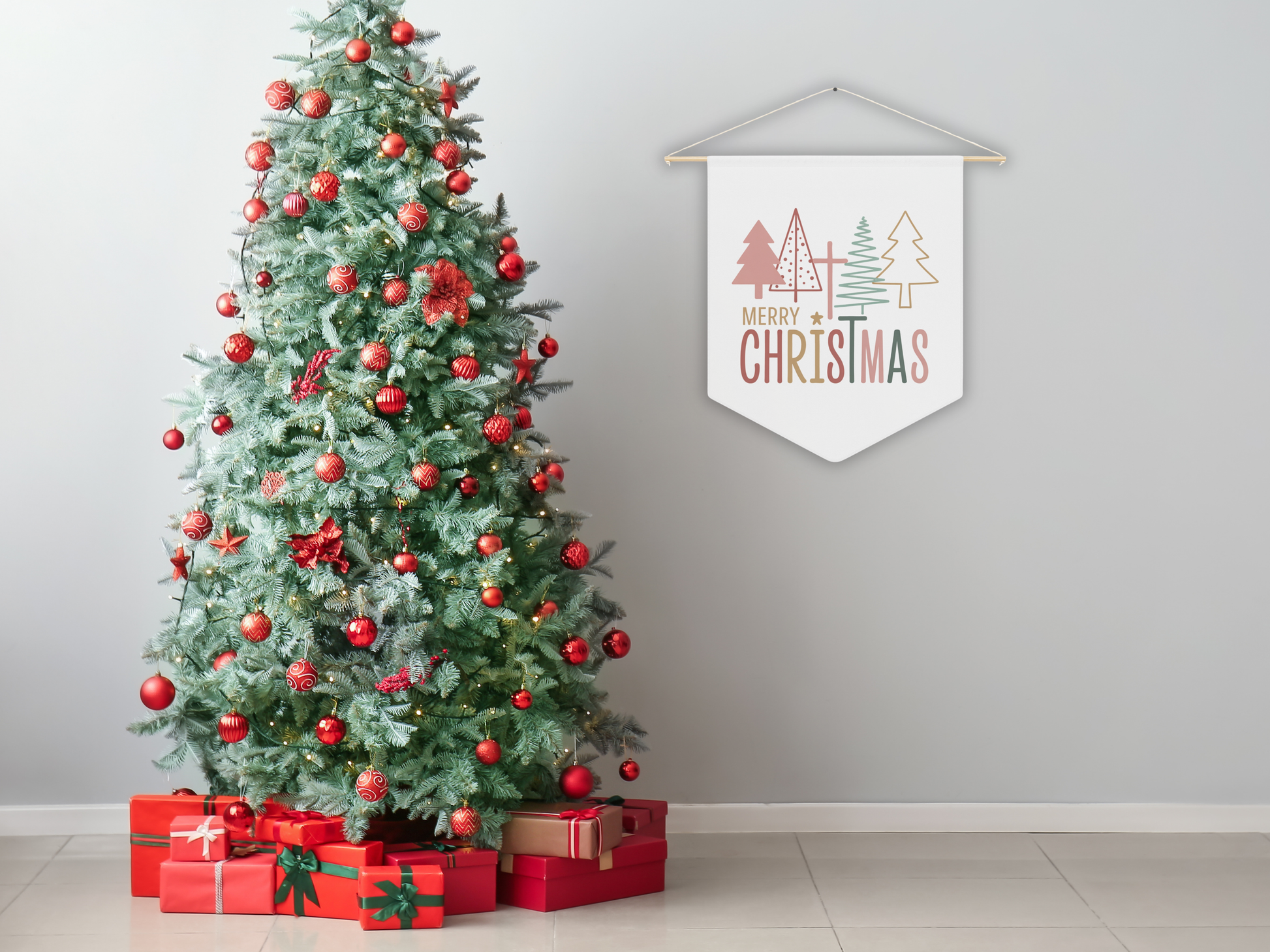 Decorated Christmas tree with red ornaments and presents, next to a 'Merry Christmas' sign on a plain wall.