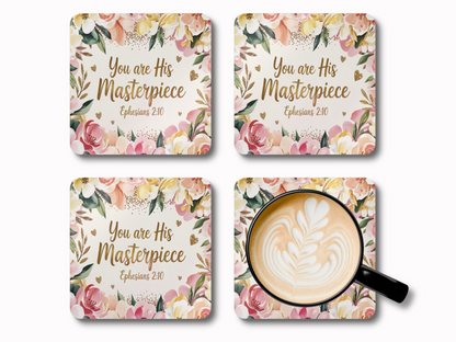 Set of four square floral coasters with “You are His Masterpiece – Ephesians 2:10” in gold script, styled with latte art coffee cup.