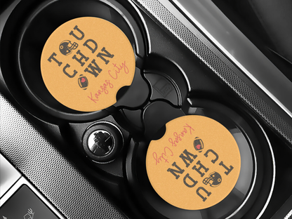 Two car coasters with branded designs in a car cup holder.