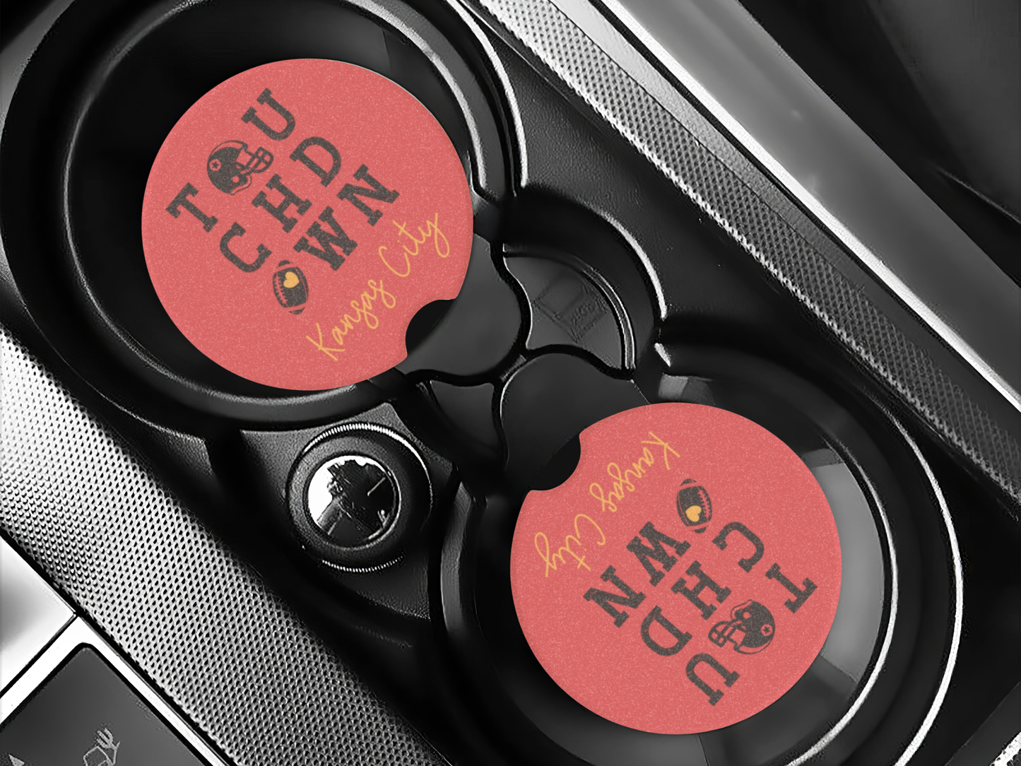 Car cup holder with two red coasters labeled 'Don'tcha Want It' on a car interior background.