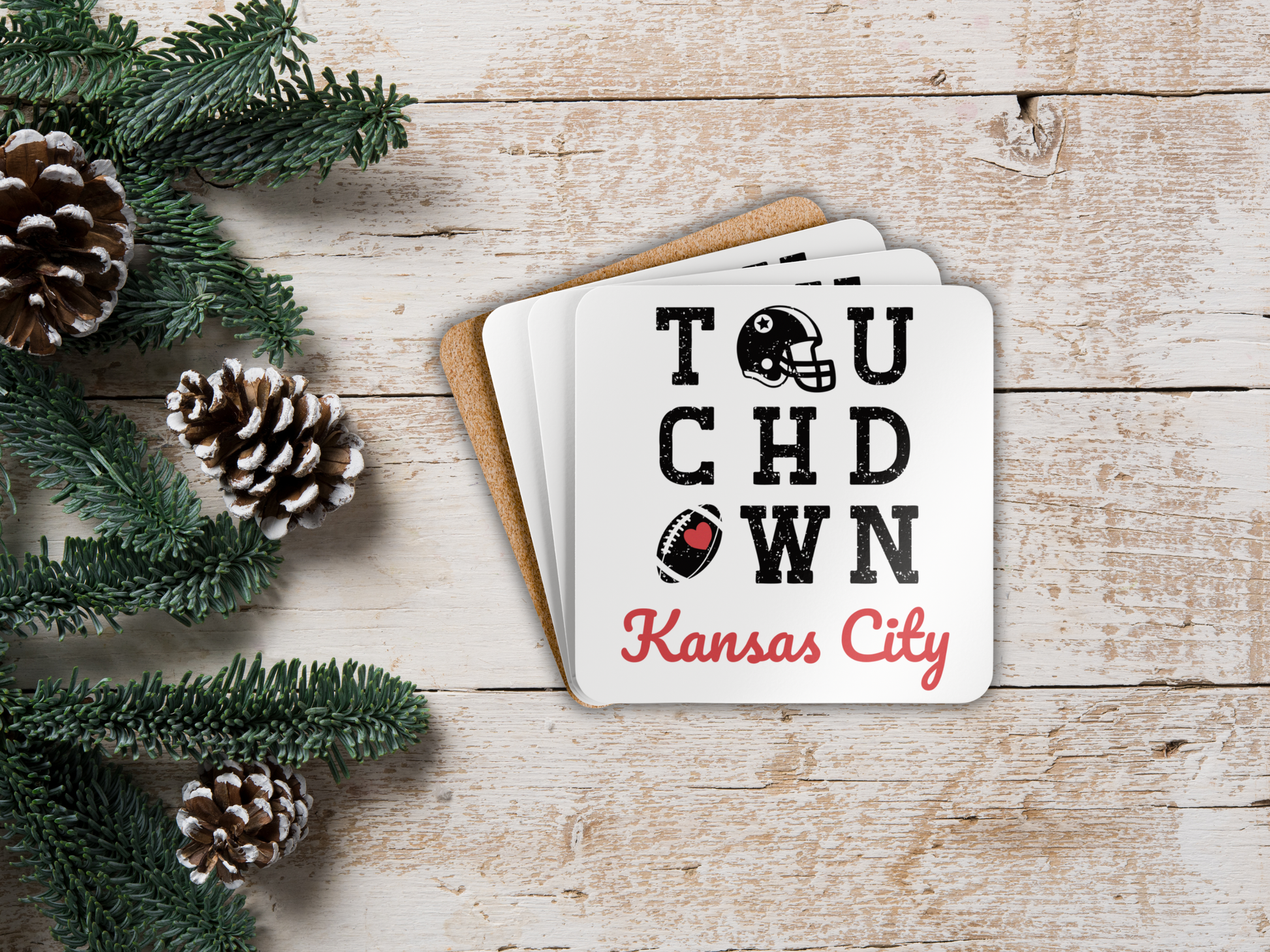 Coasters with 'Touchdown Kansas City' text on a wooden surface with Christmas decorations.