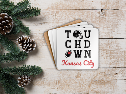 Coasters with 'Touchdown Kansas City' text on a wooden surface with Christmas decorations.
