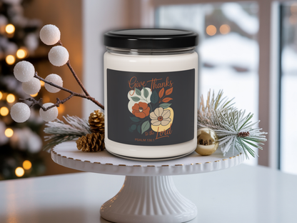 Candle with a 'Give Thanks' label on a white stand with decorative elements.