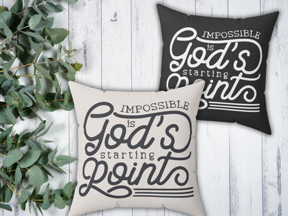 Two pillows with motivational phrases on a wooden surface with greenery.