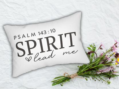 Decorative pillow with 'PSALM 143:10 SPIRIT lead me' text on a white surface with flowers.