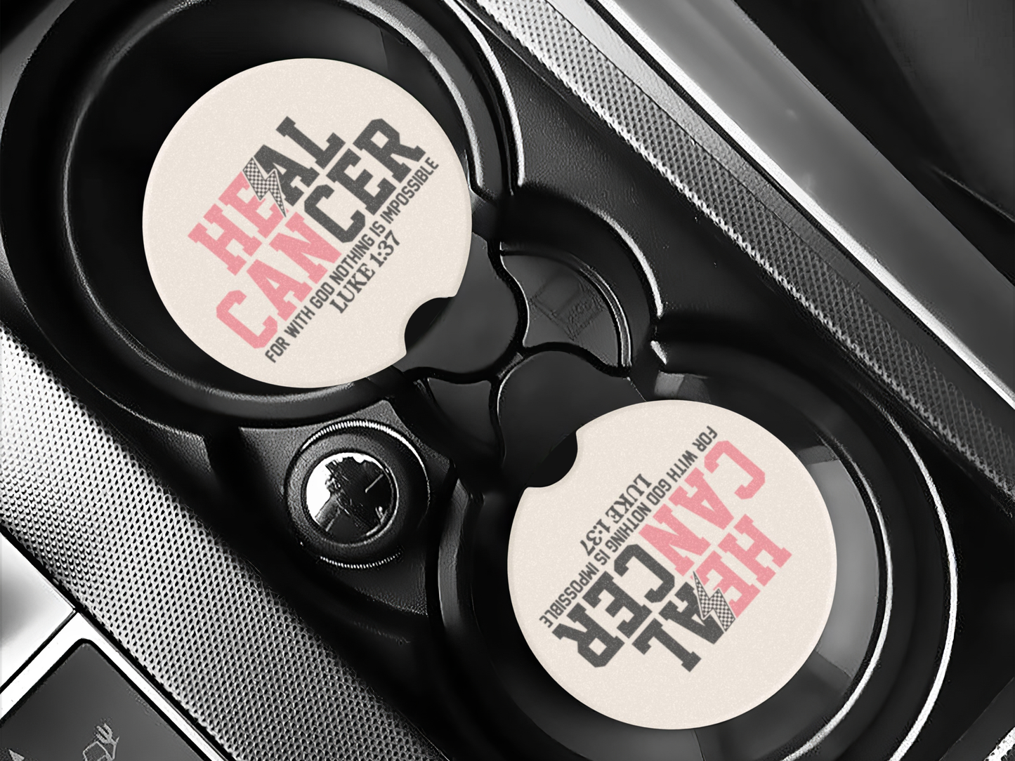 Car cup holder with 'Heal Cancer' coasters on a car dashboard