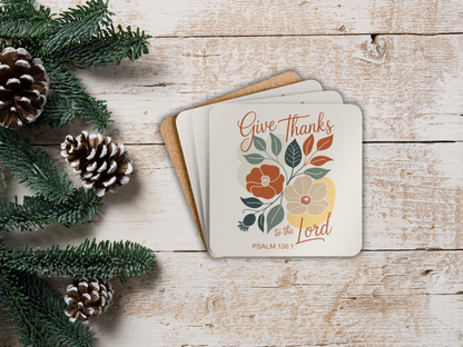 Coaster set  with 'Give Thanks to the Lord' text on a wooden surface with pinecones and greenery.