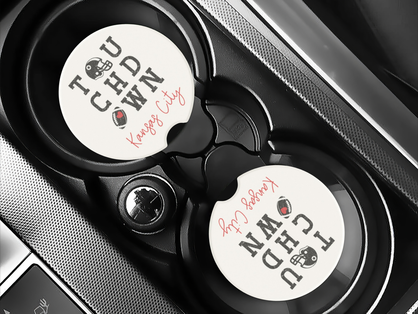 Car cup holder with two branded coasters inside a vehicle.