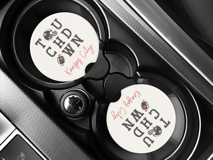 Car cup holder with two branded coasters inside a vehicle.