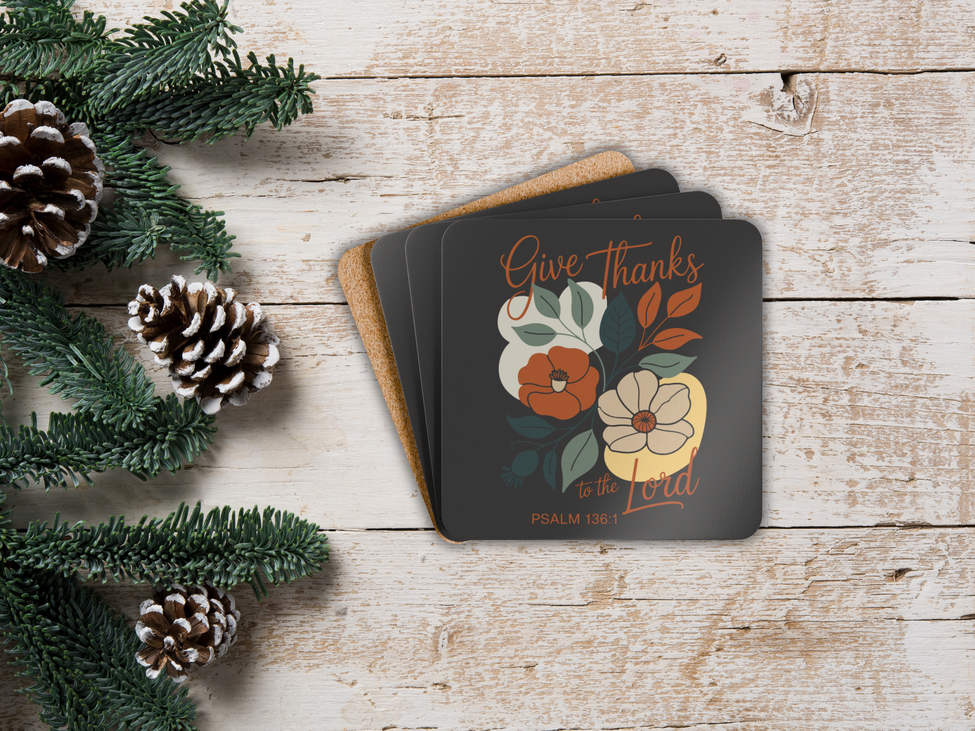 Coaster set with floral design and 'Give Thanks' text on a wooden surface with pine cones and greenery.