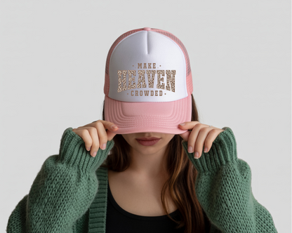 Person wearing a pink and white cap with text, holding it over their face against a plain background