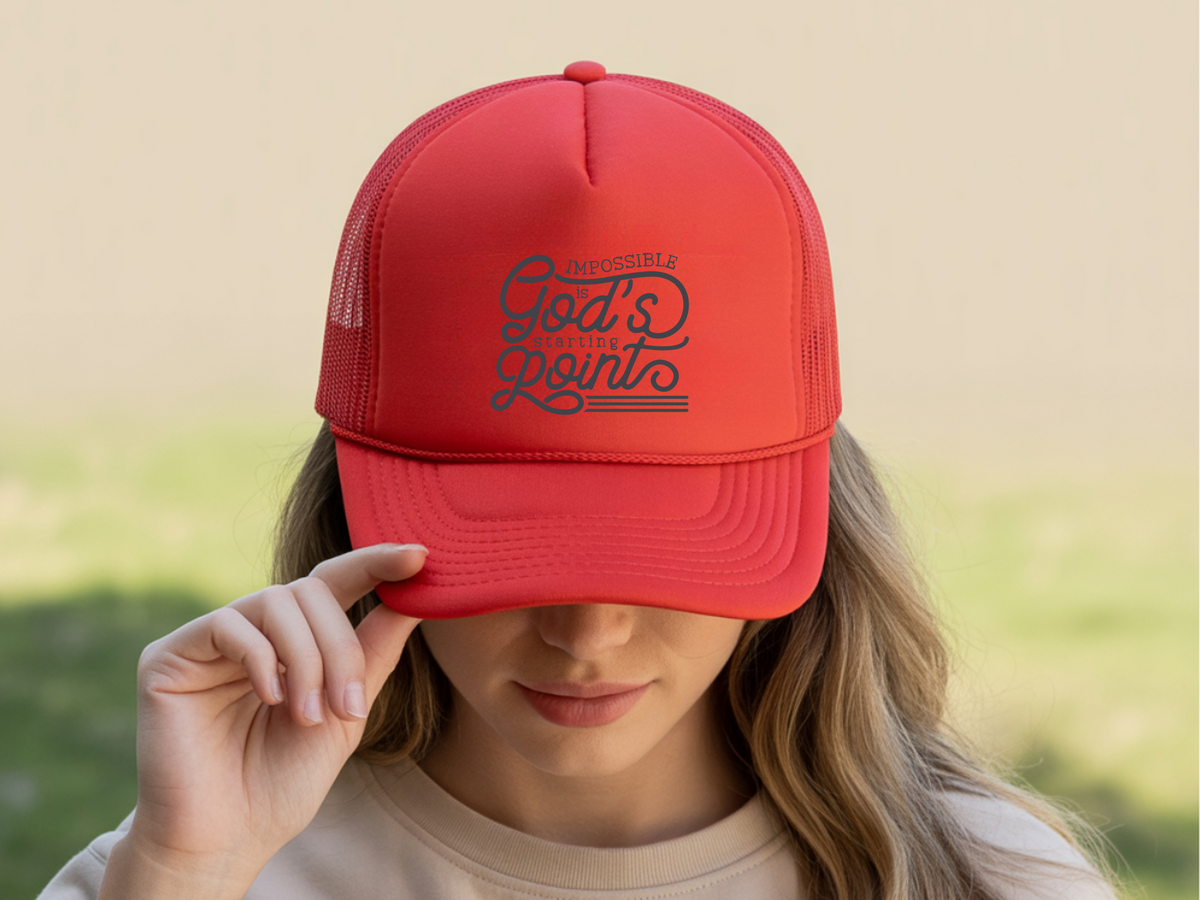Red cap with text worn by a person against a blurred natural background