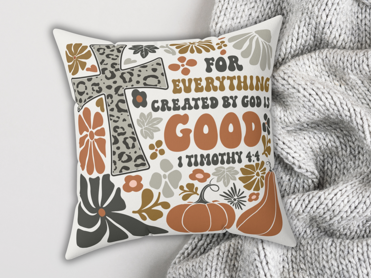 Inspirational Bible verse pillow with leopard print cross and pumpkins, laid on soft gray knit blanket for cozy seasonal decor.