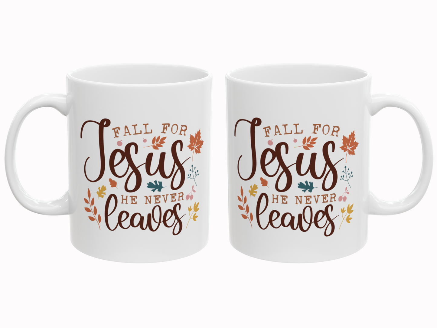 Two white mugs with 'Fall for Jesus He Never Leaves' text and leaf designs on a white background.