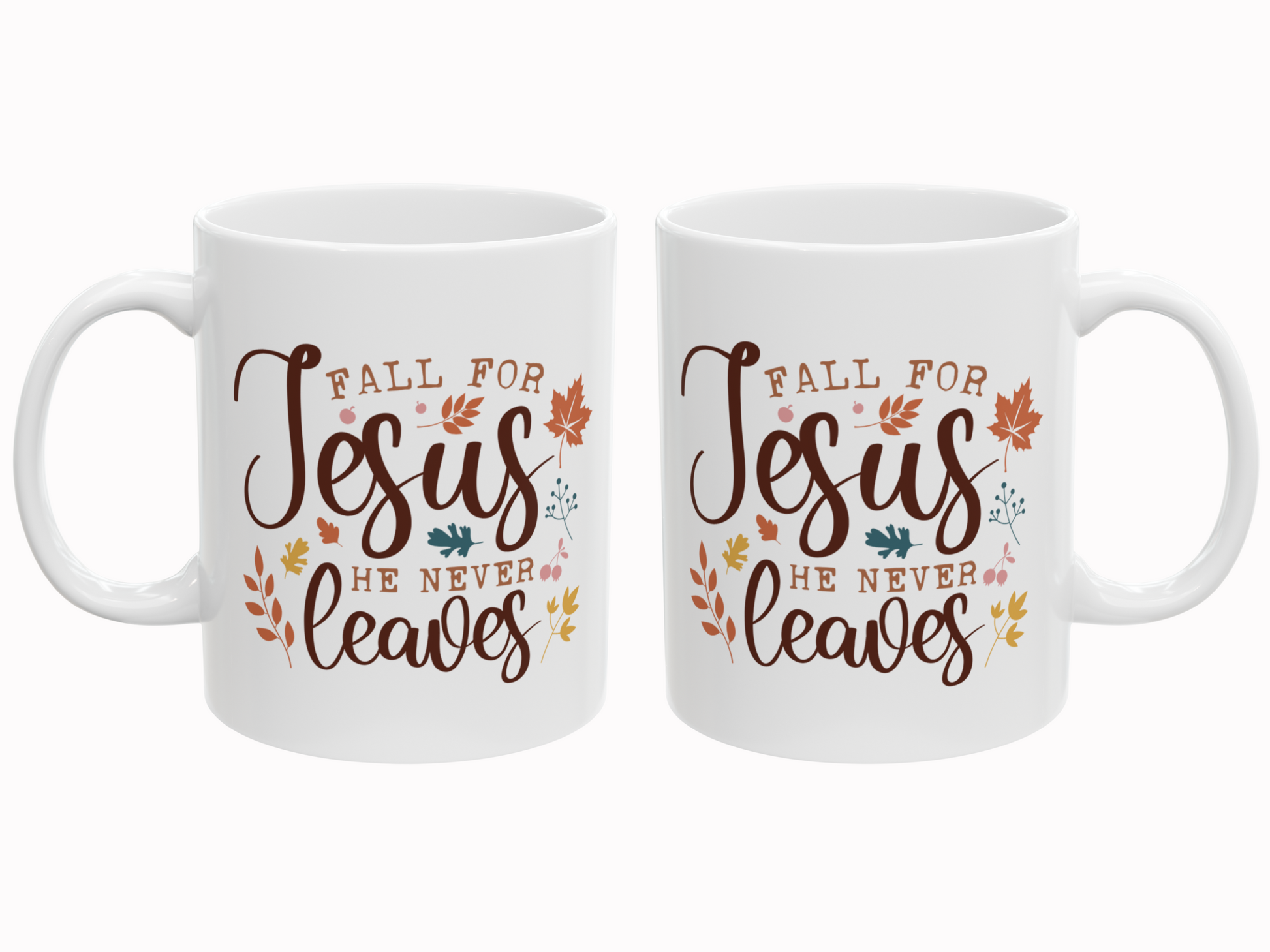 Two white mugs with 'Fall for Jesus He Never Leaves' text and leaf designs on a white background.