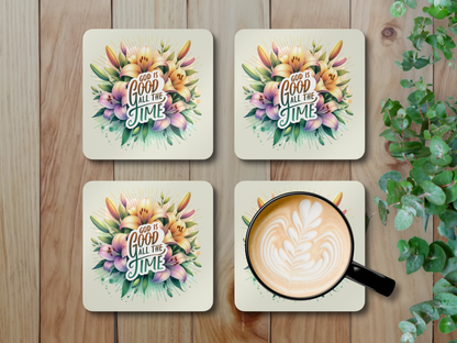 Set of four Christian floral coasters with latte art coffee mug, displayed on wooden surface with green leafy plant.