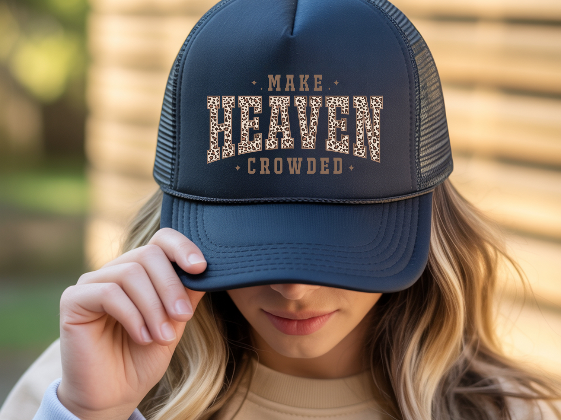 Person wearing a navy blue cap with 'MAKE HEAVEN CROWDED' text.