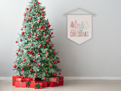 Decorated Christmas tree with red ornaments and presents underneath, against a plain wall with a 'Merry Christmas' sign.