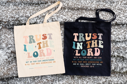 Two tote bags with 'Trust in the Lord' text on a textured surface