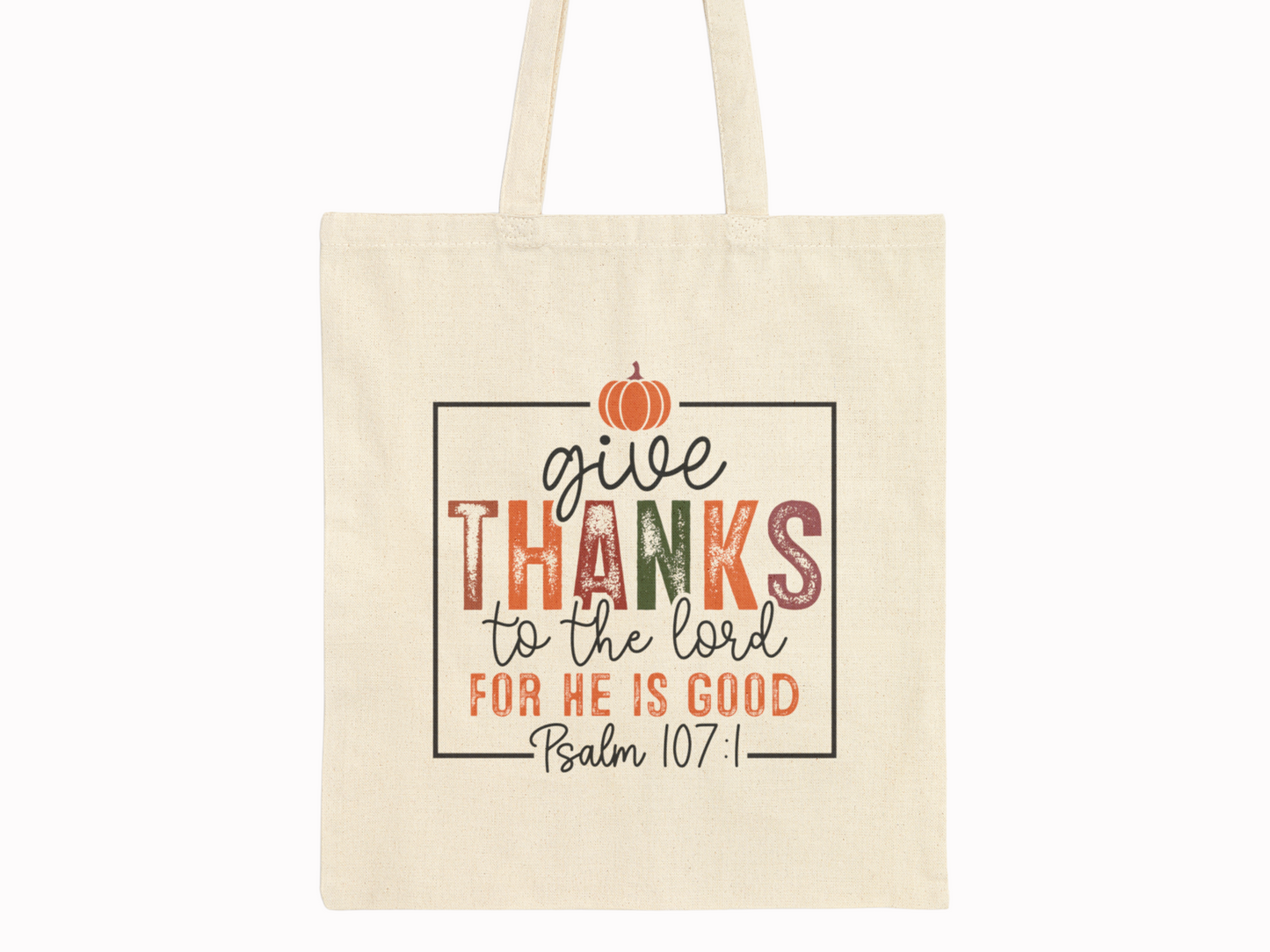 Canvas tote bag with "Give thanks to the Lord for He is good, Psalm 107:1" in colorful letters. A small orange pumpkin decorates the top.