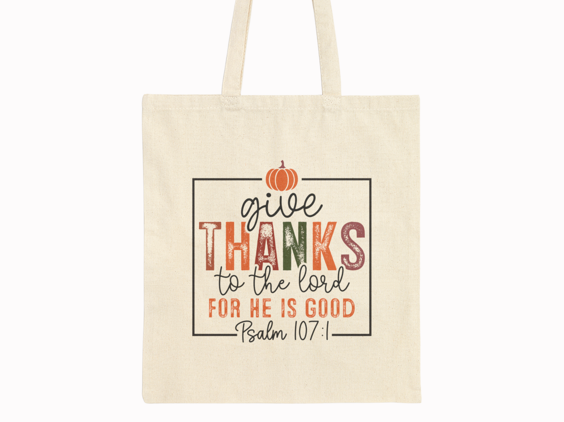 Canvas tote bag with "Give thanks to the Lord for He is good, Psalm 107:1" in colorful letters. A small orange pumpkin decorates the top.