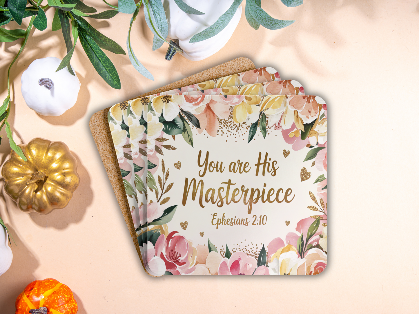 Stack of floral coasters with Ephesians 2:10 verse styled with pumpkins and greenery, giving a warm autumn-inspired look.