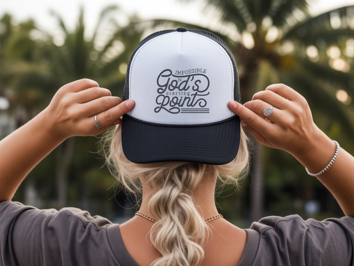 Person holding a cap with text against a blurred natural background