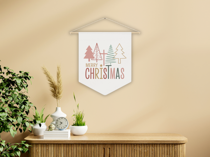 Decorative Christmas banner with trees and 'Merry Christmas' text on a beige wall above a wooden console table.