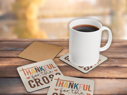 Christian coasters with cork backing styled with a white mug of coffee on wooden table and blurred autumn view.