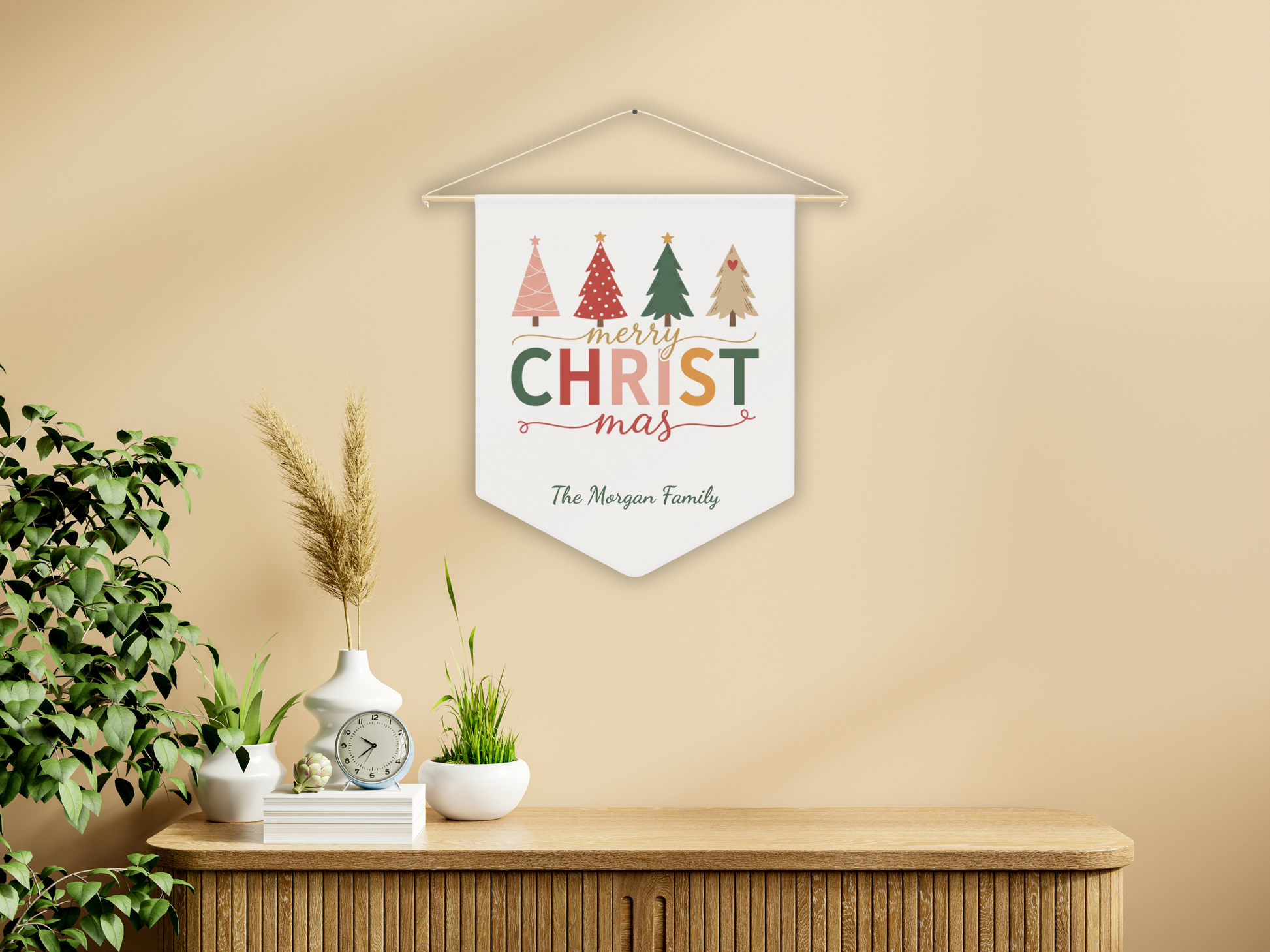 Decorative sign with 'Merry Christmas' text and Christmas trees on a beige wall.