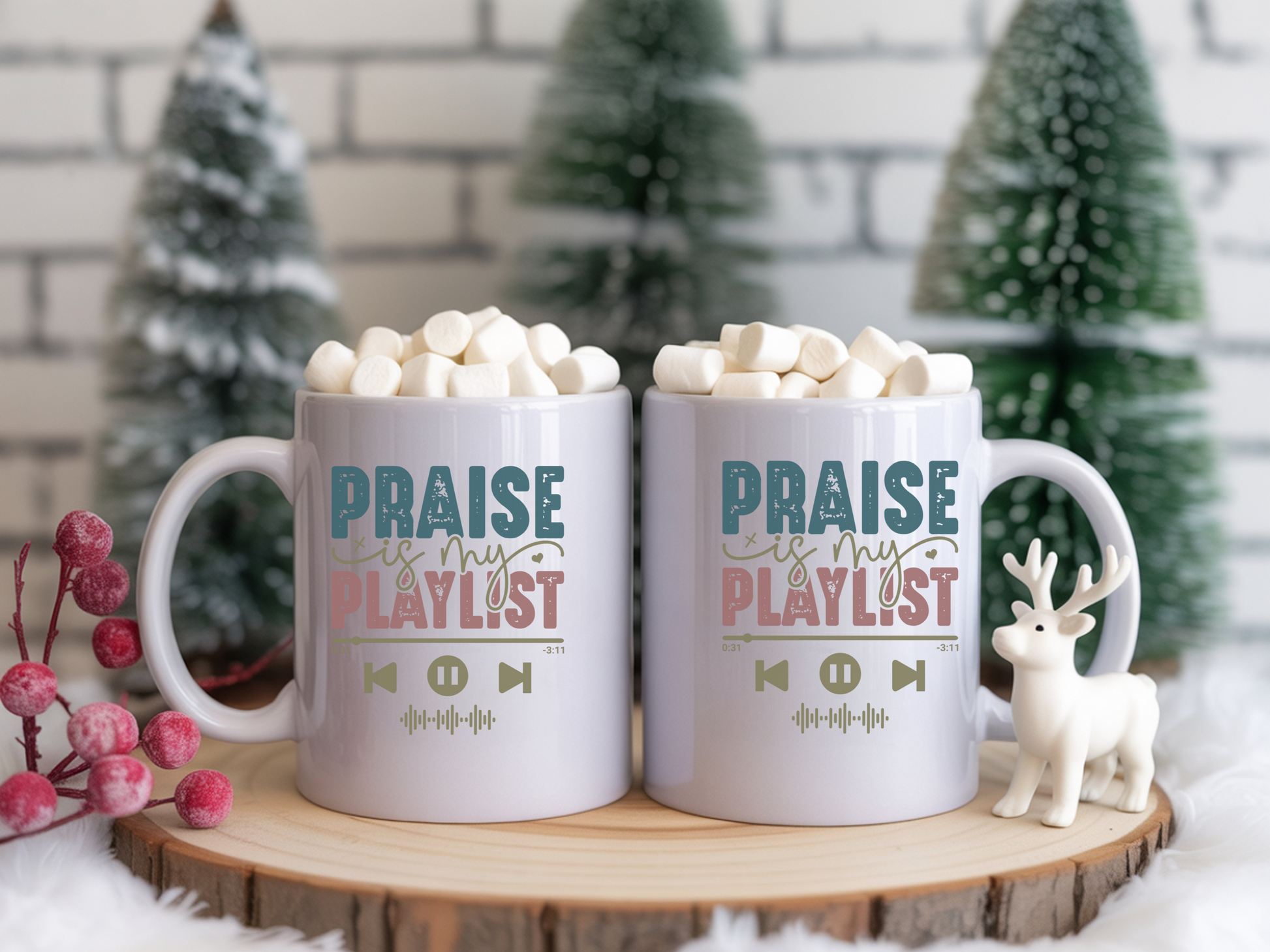Two mugs with 'Praise is my playlist' text on a wooden stand with Christmas decorations.