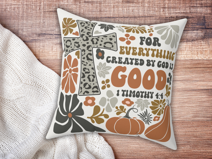 Christian decorative pillow with 1 Timothy 4:4 verse, leopard cross, pumpkins, and florals, displayed on wooden surface beside cream knit blanket.