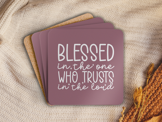 Stacked coasters on a beige knit blanket with dried florals and cork backing visible.