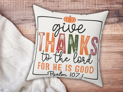 Scripture pillow on wooden surface paired with chunky white knit blanket.