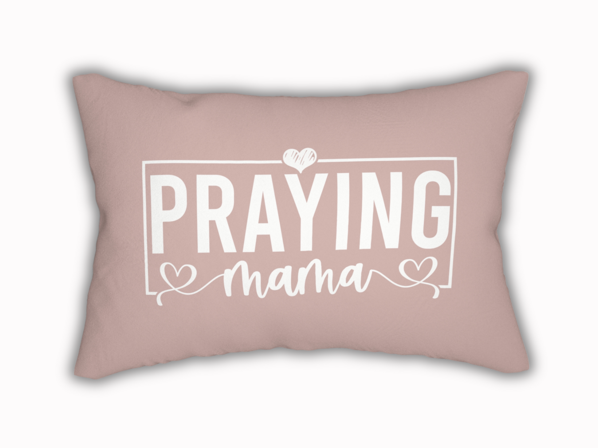 Rectangular blush pink pillow with white text design reading “Praying Mama” in bold and script font, accented with hearts.