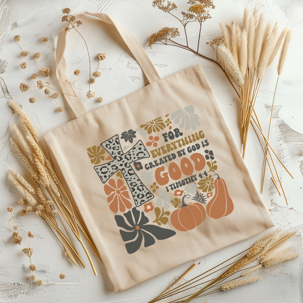 Beige tote bag with autumn-themed design and text on a light background with dried plants.