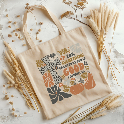 Beige tote bag with autumn-themed design and text on a light background with dried plants.